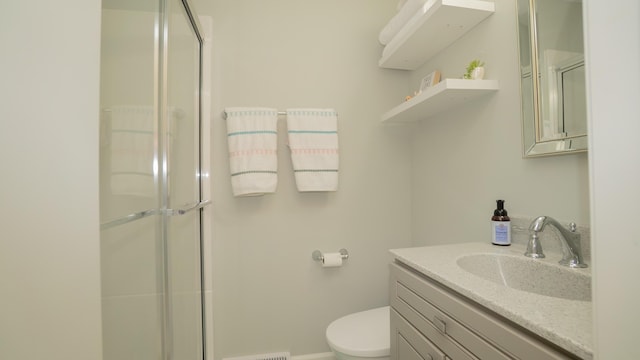 bathroom featuring an enclosed shower, toilet, visible vents, and vanity