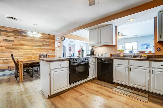 kitchen featuring visible vents, white cabinets, a sink, a peninsula, and black appliances