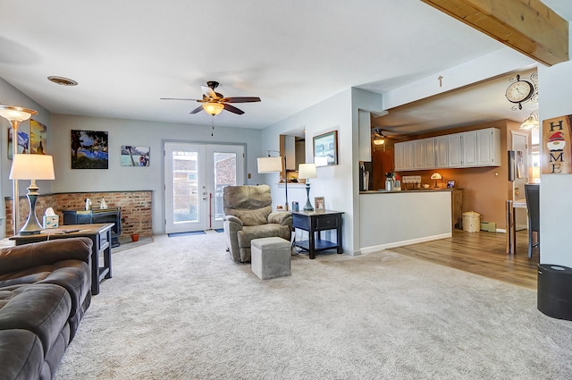 living area with french doors, beam ceiling, a ceiling fan, light carpet, and baseboards