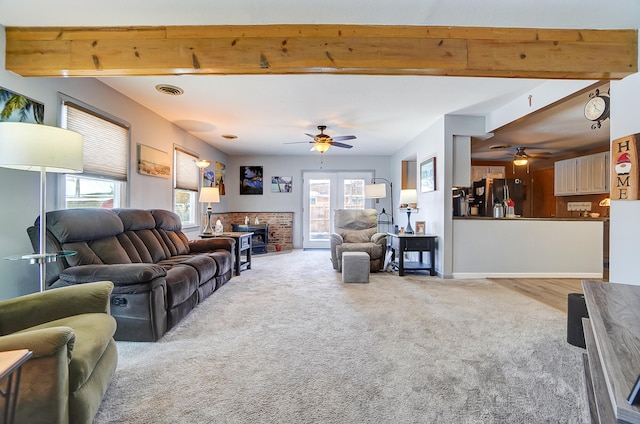 living area featuring baseboards, visible vents, a ceiling fan, carpet flooring, and beam ceiling