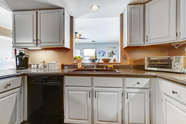 kitchen featuring dishwasher, dark countertops, a sink, and white cabinets