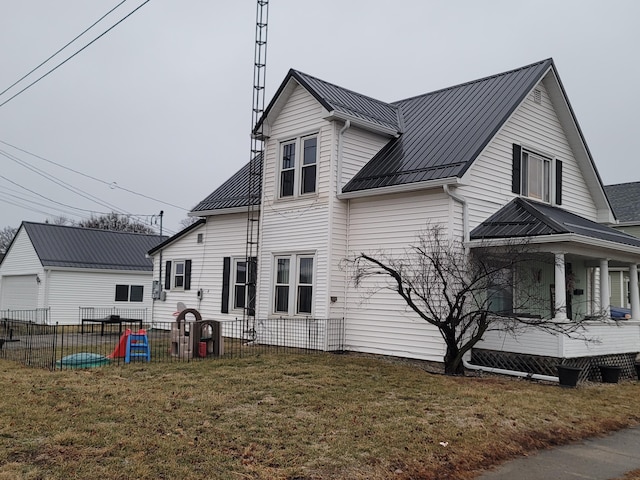 back of house featuring covered porch and a lawn