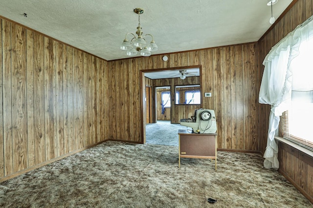 1024 Ansel Dr, Dayton, OH 45419 - unfurnished dining area featuring carpet floors, a chandelier, wooden walls, a textured ceiling, and a ceiling fan