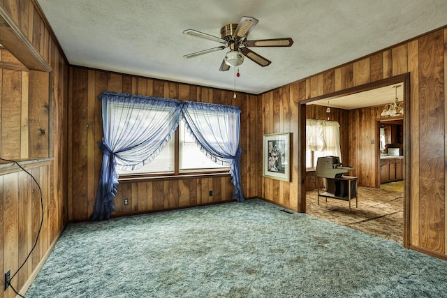 1024 Ansel Dr, Dayton, OH 45419 - unfurnished living room featuring carpet, ceiling fan, a textured ceiling, and wooden walls