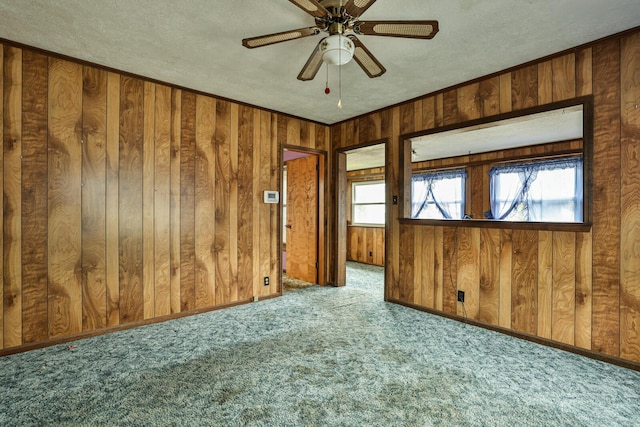 1024 Ansel Dr, Dayton, OH 45419 - carpeted empty room featuring wooden walls, a textured ceiling, and ceiling fan