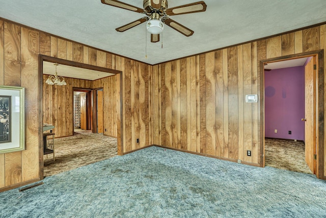 1024 Ansel Dr, Dayton, OH 45419 - empty room featuring carpet floors, a chandelier, wood walls, a ceiling fan, and a textured ceiling