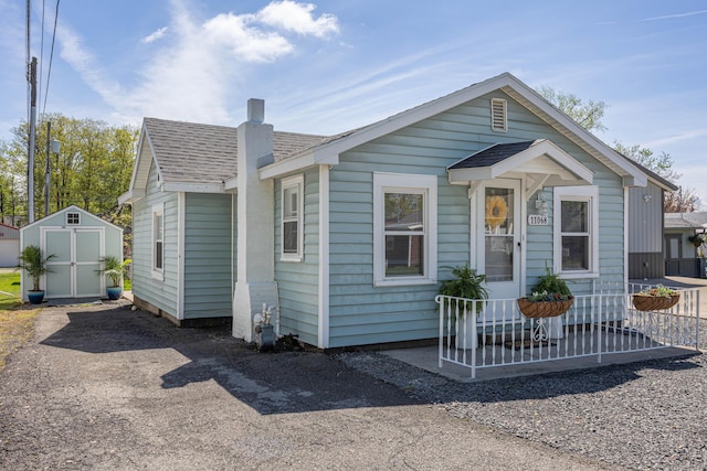 11068 Big Bear Path, Lakeview, OH 43331 - view of front of home with a storage unit, a chimney, and a shingled roof