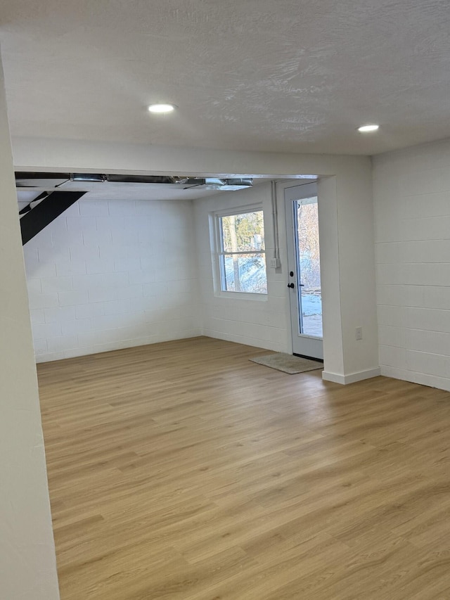 empty room with light hardwood / wood-style flooring and a textured ceiling