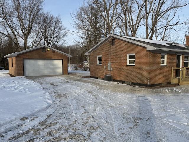 view of snow covered exterior with an outbuilding and a garage