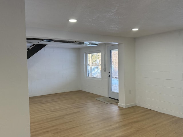 interior space with a textured ceiling and light hardwood / wood-style floors