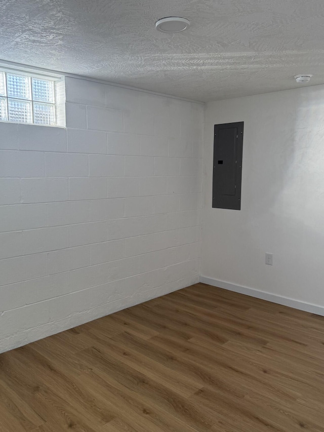 spare room with hardwood / wood-style flooring, electric panel, and a textured ceiling