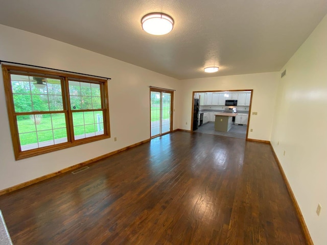 4344 N US Highway 68, West Liberty, OH 43357 - spare room with baseboards, dark wood-style floors, and visible vents