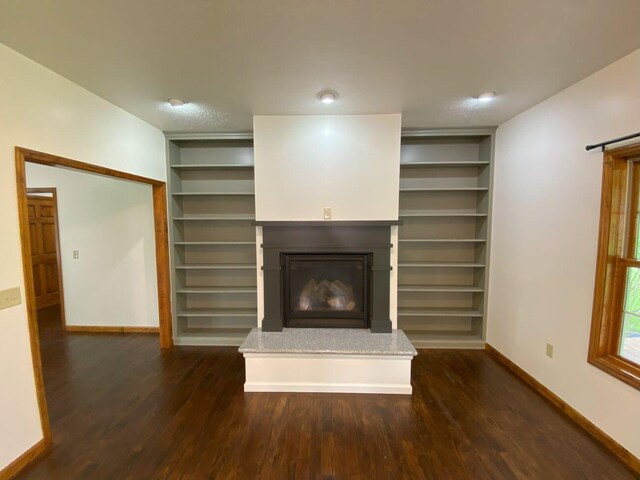 4344 N US Highway 68, West Liberty, OH 43357 - unfurnished living room featuring baseboards, dark wood-style floors, and a glass covered fireplace