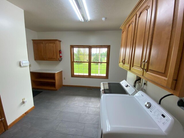 4344 N US Highway 68, West Liberty, OH 43357 - laundry room featuring cabinet space, washer and clothes dryer, baseboards, and a textured ceiling