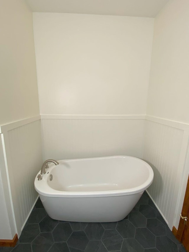 4344 N US Highway 68, West Liberty, OH 43357 - bathroom with tile patterned flooring, a decorative wall, a freestanding tub, and a wainscoted wall