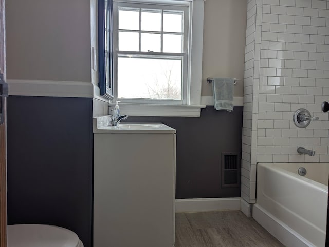 full bath with shower / tub combination, toilet, vanity, visible vents, and baseboards