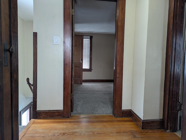 corridor featuring light wood-style floors and baseboards