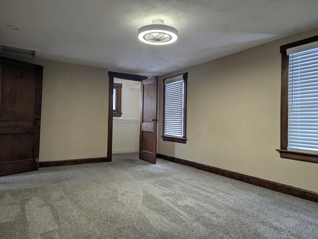 unfurnished bedroom with light colored carpet, visible vents, and baseboards