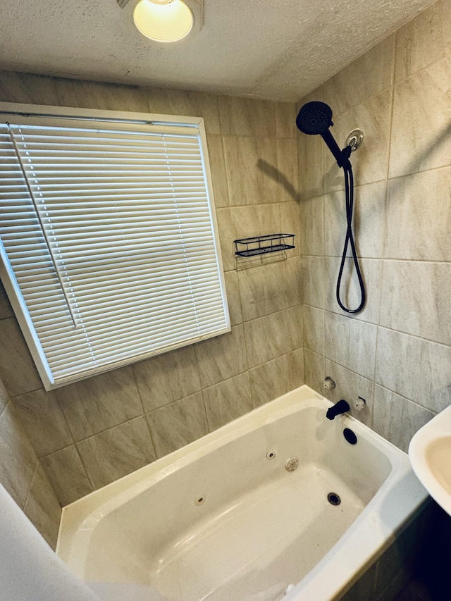 bathroom with a textured ceiling and a combined bath / shower with jetted tub