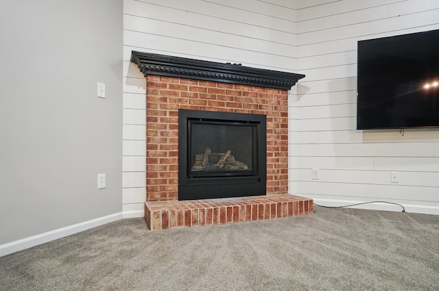 details featuring a brick fireplace, baseboards, and carpet flooring