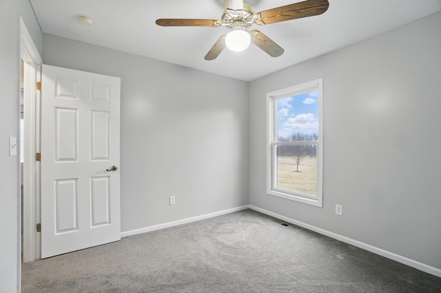 empty room featuring a ceiling fan, visible vents, baseboards, and carpet flooring