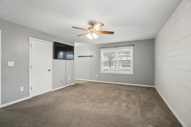 unfurnished room with carpet floors, a ceiling fan, and baseboards