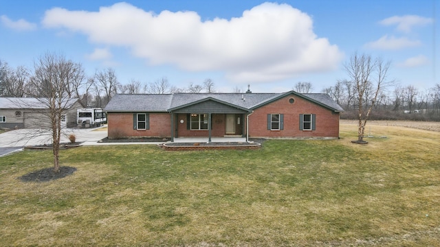 single story home featuring driveway, brick siding, and a front yard