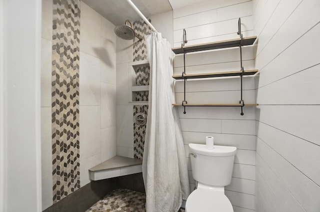 full bathroom with a tile shower and toilet