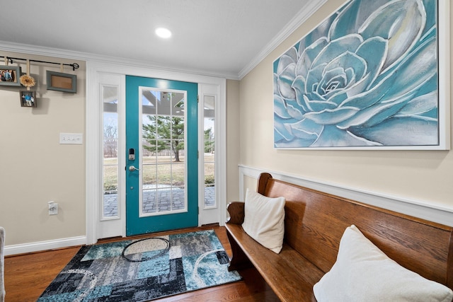 foyer featuring baseboards, wood finished floors, and ornamental molding