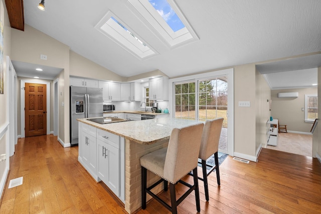 kitchen featuring white cabinetry, a breakfast bar area, visible vents, and appliances with stainless steel finishes