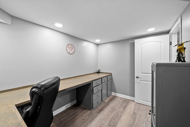 home office with recessed lighting, wood finished floors, baseboards, and built in study area