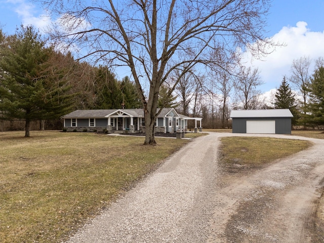 single story home featuring covered porch, a front yard, a detached garage, and an outdoor structure