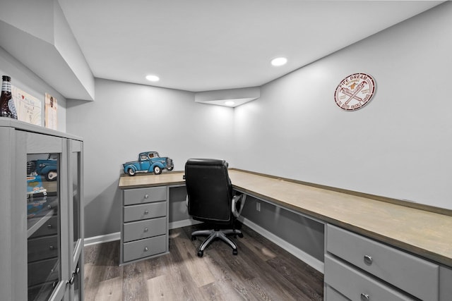 office space with dark wood finished floors, built in desk, recessed lighting, and baseboards