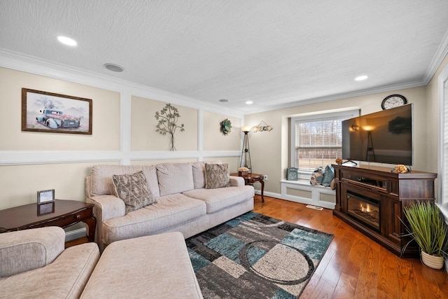 living room featuring visible vents, ornamental molding, a textured ceiling, wood finished floors, and recessed lighting