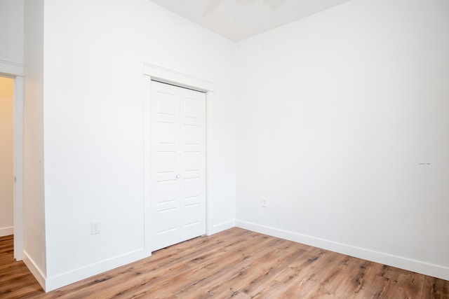 unfurnished bedroom featuring light hardwood / wood-style floors and a closet