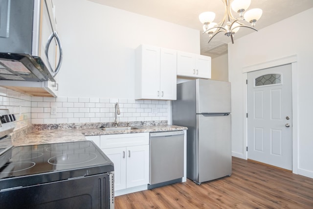 kitchen featuring white cabinetry, appliances with stainless steel finishes, sink, and hanging light fixtures