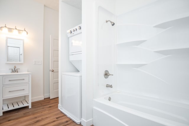 bathroom featuring stacked washer and clothes dryer, a textured ceiling, shower / washtub combination, vanity, and hardwood / wood-style floors