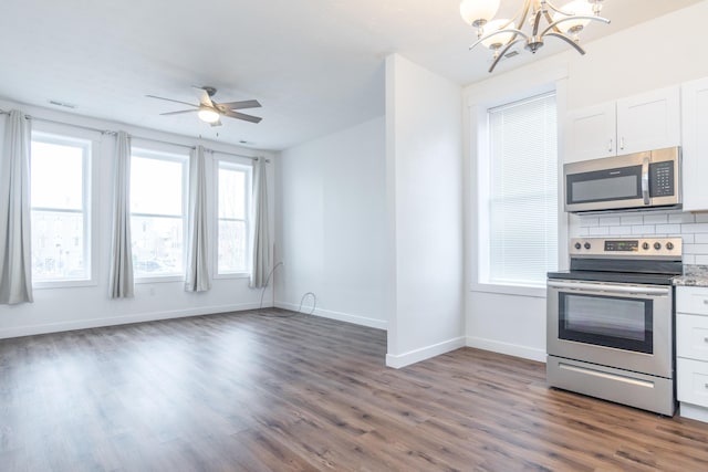 kitchen featuring tasteful backsplash, appliances with stainless steel finishes, dark hardwood / wood-style flooring, ceiling fan with notable chandelier, and white cabinets