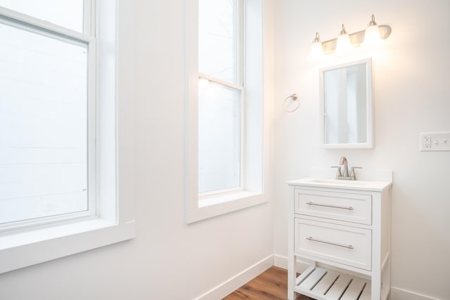 bathroom with vanity, hardwood / wood-style floors, and a healthy amount of sunlight