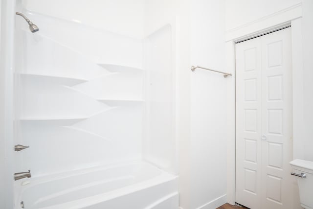 bathroom with tub / shower combination and toilet