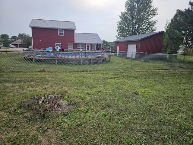 6822 Watercraft Dr, Huntsville, OH 43324 - back of house featuring a garage, a metal roof, a fenced backyard, and an outbuilding