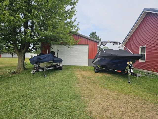 6822 Watercraft Dr, Huntsville, OH 43324 - view of grassy yard featuring a detached garage, an outdoor structure, and driveway