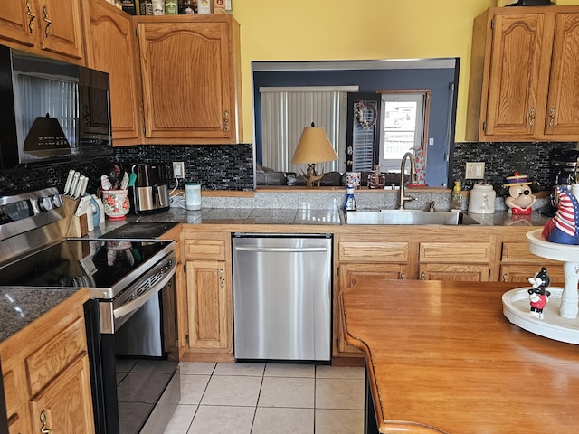 6822 Watercraft Dr, Huntsville, OH 43324 - kitchen featuring appliances with stainless steel finishes, light tile patterned floors, decorative backsplash, tile counters, and brown cabinets