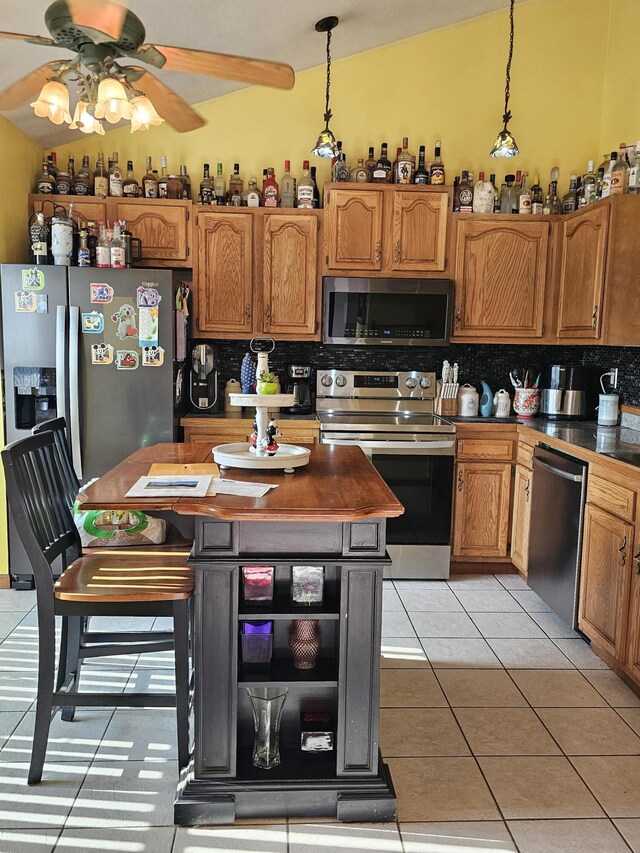 6822 Watercraft Dr, Huntsville, OH 43324 - kitchen featuring tasteful backsplash, stainless steel appliances, a ceiling fan, light tile patterned floors, and dark countertops
