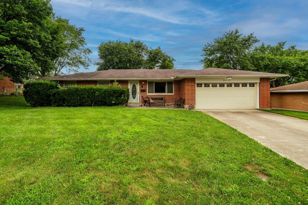2631 Camino Pl, Kettering, OH 45420 - single story home with driveway, a garage, a front lawn, and brick siding