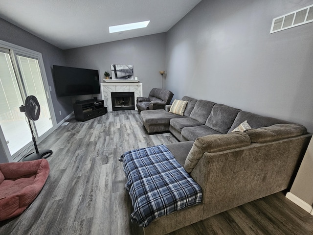 2973 Kicking Bird Trce, Dublin, OH 43017 - living room with wood finished floors, vaulted ceiling, a skylight, and a high end fireplace