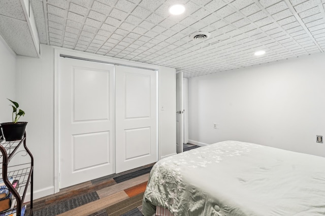 bedroom featuring dark wood-type flooring, a closet, visible vents, and recessed lighting