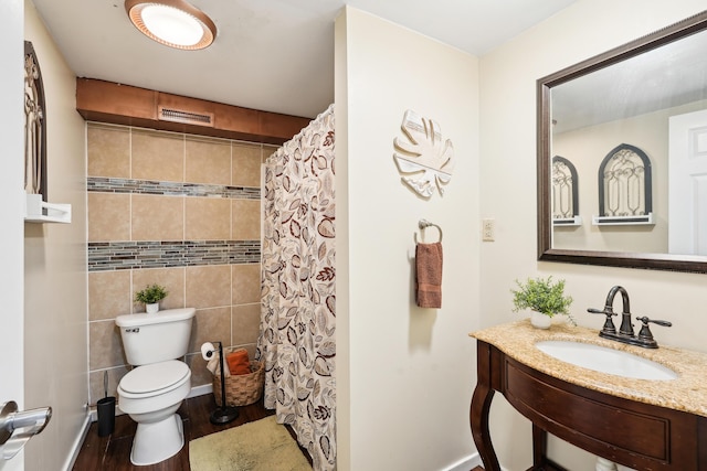 bathroom featuring toilet, wood finished floors, a sink, and curtained shower