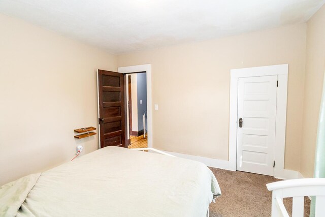 bedroom with baseboards and light carpet