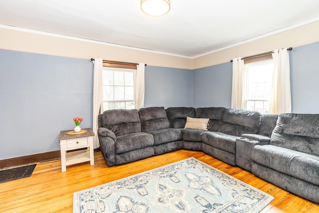 living room with ornamental molding, visible vents, and wood finished floors